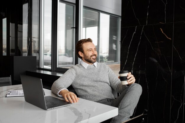 Medium shot smiley man sitting at desk