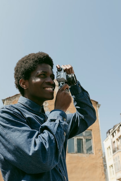 Uomo sorridente di tiro medio che scatta foto