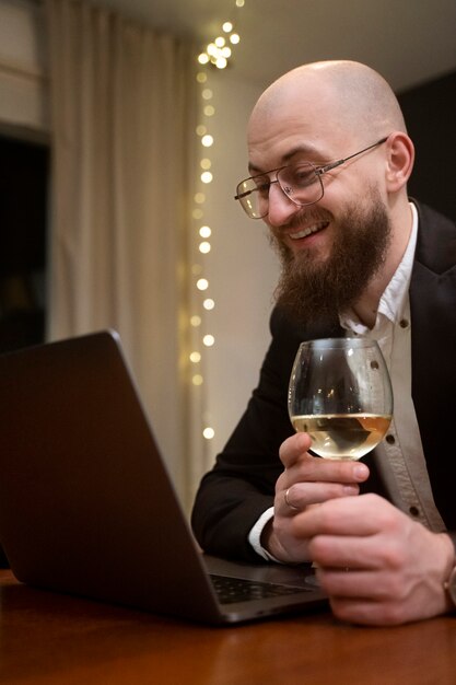 Medium shot smiley man at virtual date with laptop