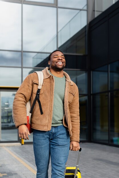 Medium shot smiley man walking with baggage