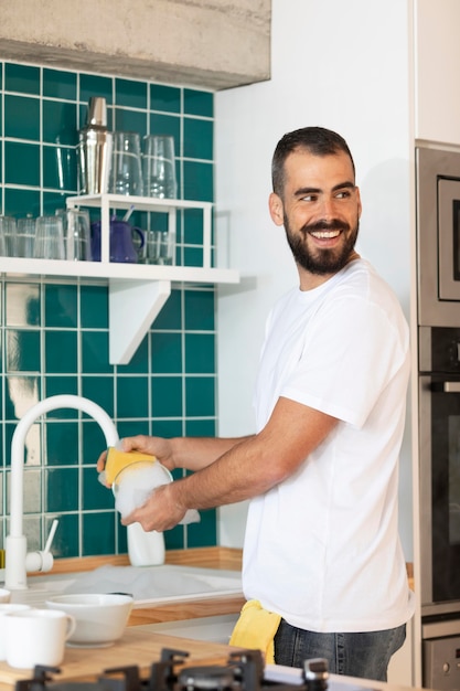 Medium shot smiley man washing dish