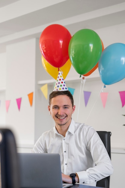 Medium shot smiley man wearing party hat