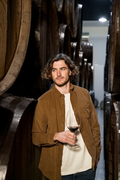 Medium shot smiley man in wine cellar