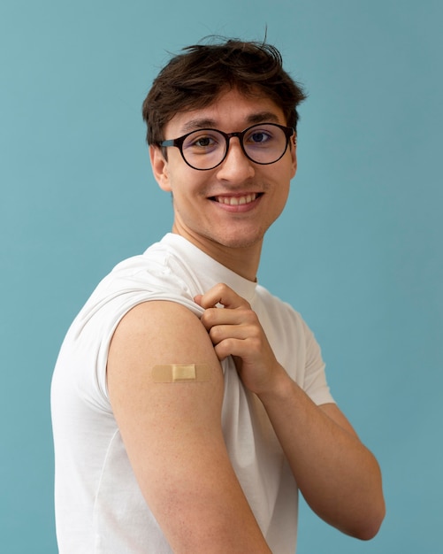 Free photo medium shot smiley man with band aid