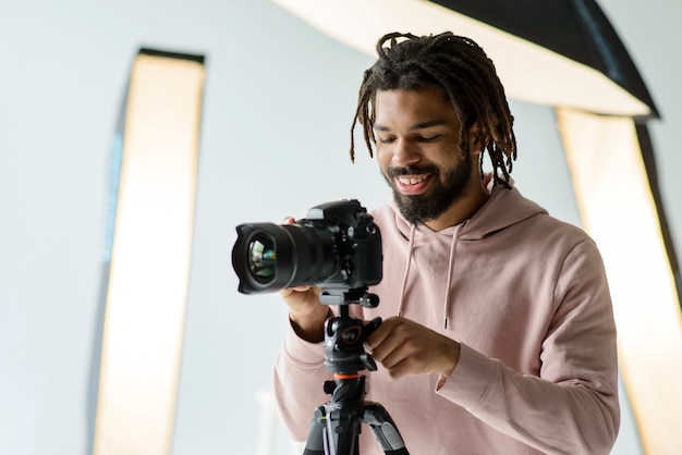 Free photo medium shot smiley man with camera