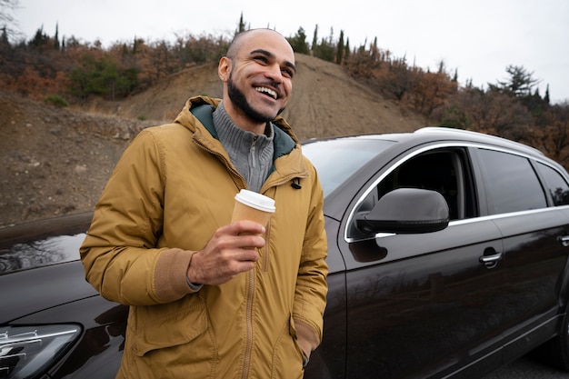 コーヒーカップとミディアムショットのスマイリー男