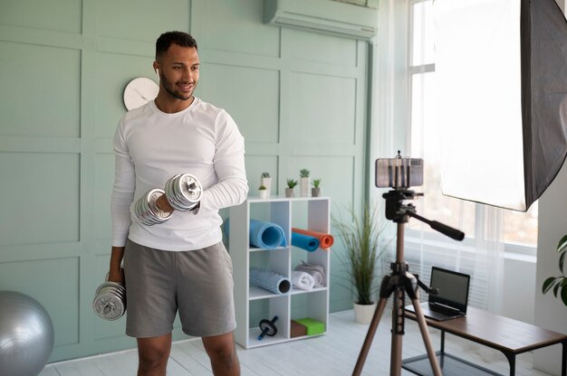 Medium shot smiley man with dumbbells