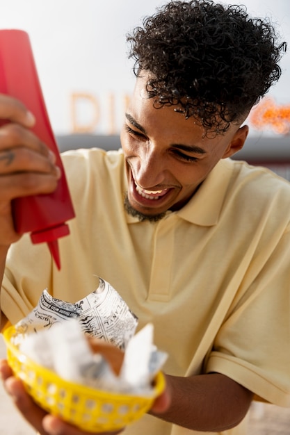 Uomo sorridente del colpo medio con ketchup