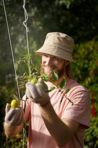 Free photo medium shot smiley man with plant