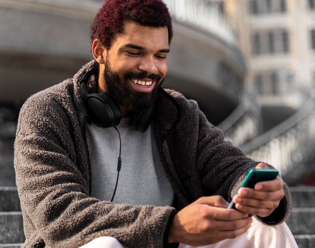 Foto gratuita uomo di smiley colpo medio con lo smartphone