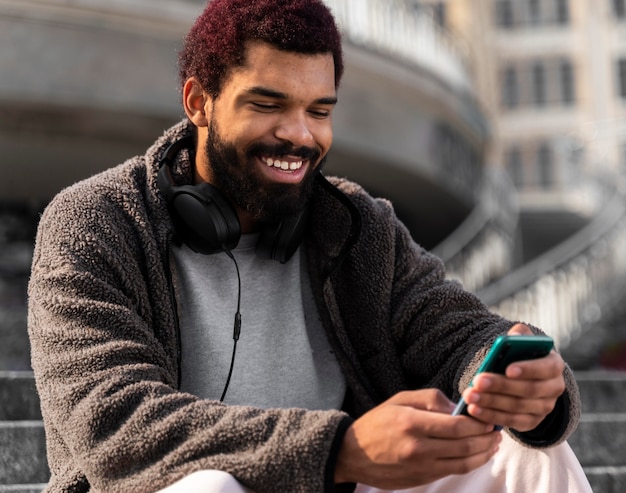 Medium shot smiley man with smartphone