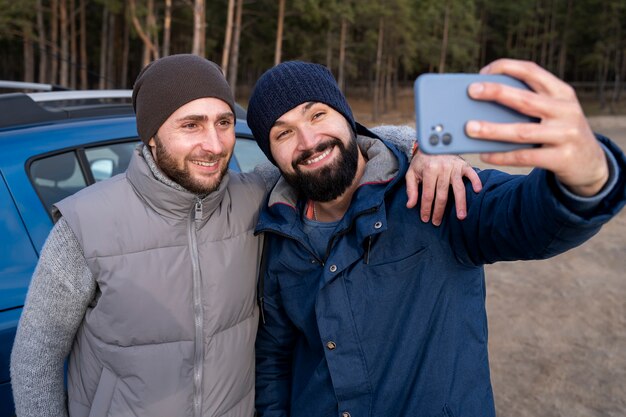 Medium shot smiley men taking selfie