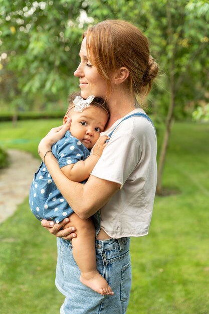 Medium shot smiley mother holding baby