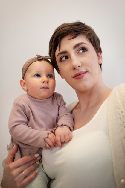 Medium shot smiley mother holding baby