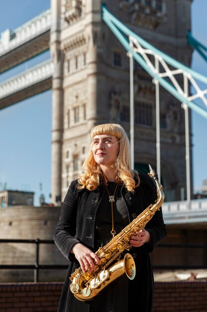 Medium shot smiley musician holding saxophone