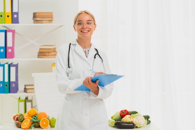 Medium shot smiley nutritionist with stethoscope 