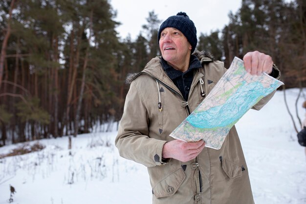 Medium shot smiley old man holding map