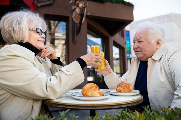 ミディアムショットのスマイリーお年寄りと飲み物