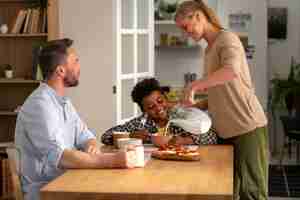 Free photo medium shot smiley parents and kid with food