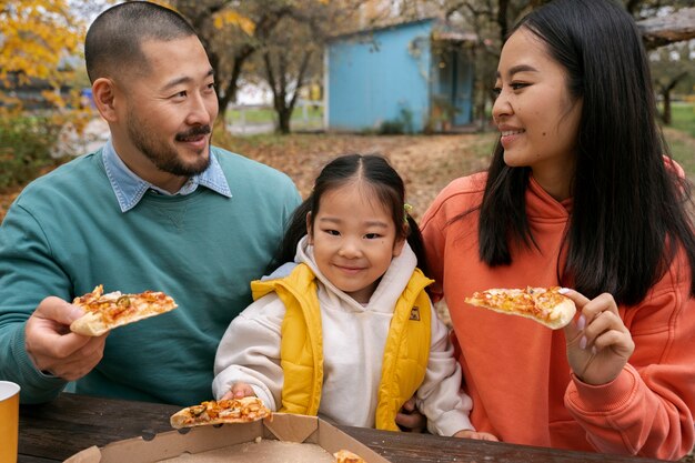 무료 사진 피자를 먹는 중간 샷 웃는 사람들