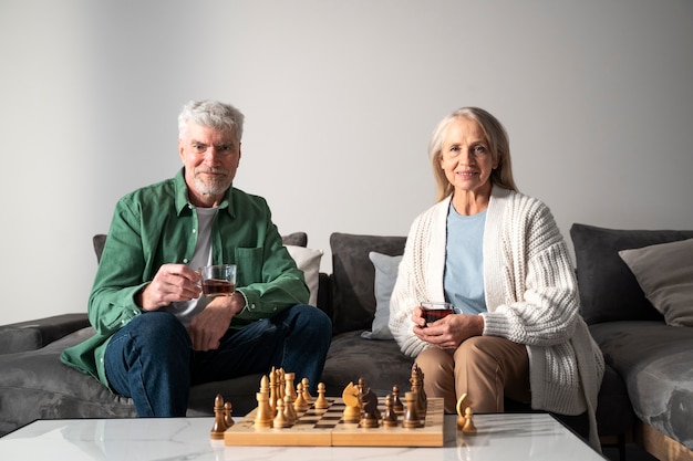 Free photo medium shot smiley people playing chess