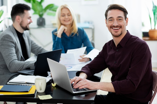 Foto gratuita persone sorridenti di tiro medio al lavoro