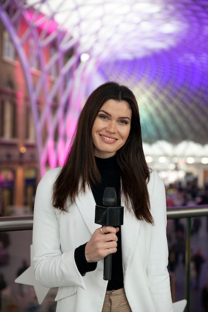 Medium shot smiley reporter with microphone