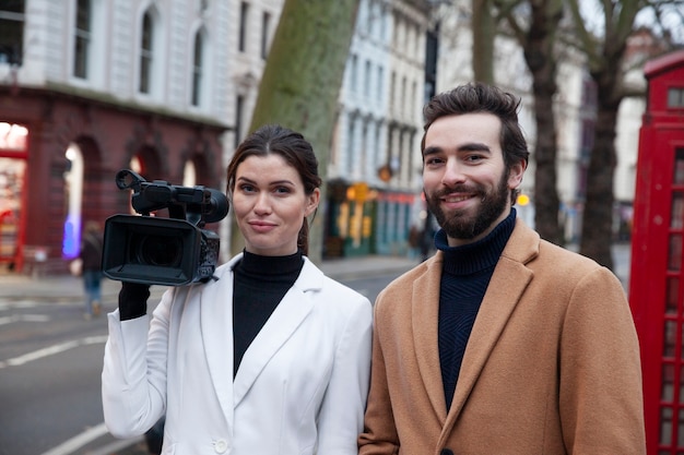 Medium shot smiley reporters with camera