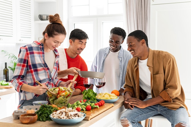 Free photo medium shot smiley roommates in kitchen