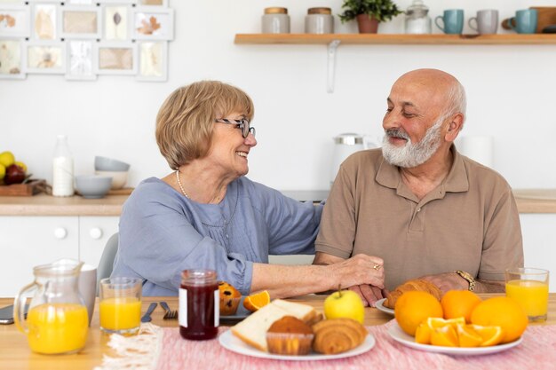 Medium shot smiley senior couple at table