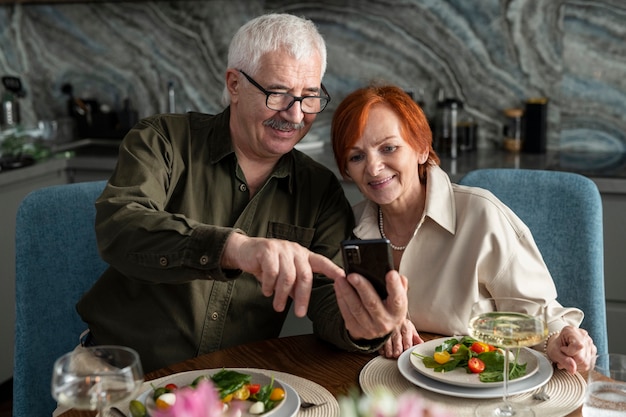 Medium shot smiley senior couple taking selfie