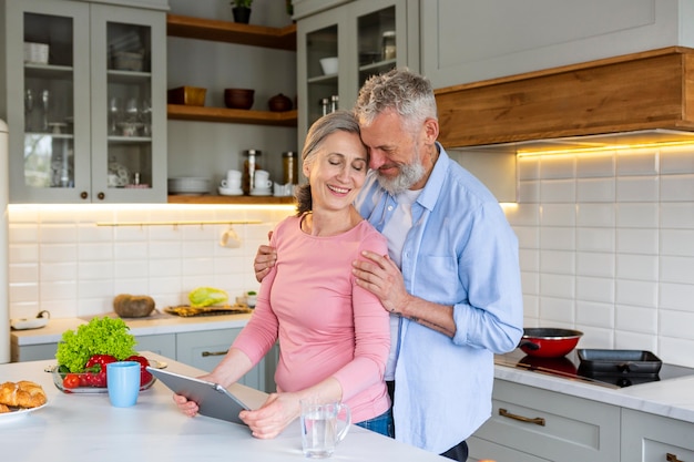 Medium shot smiley senior couple with tablet