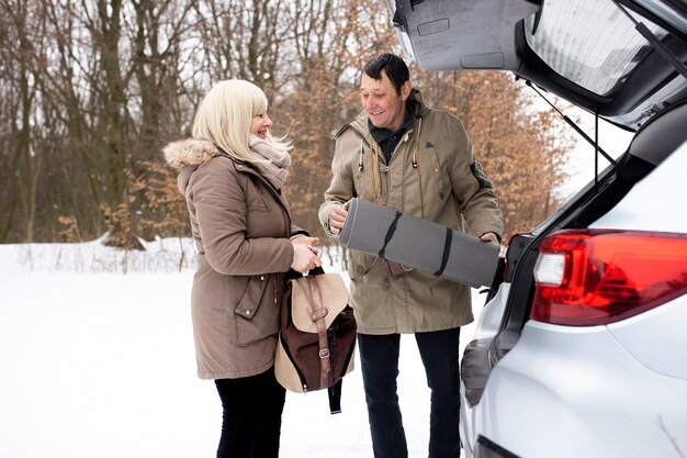 Medium shot smiley senior people with car