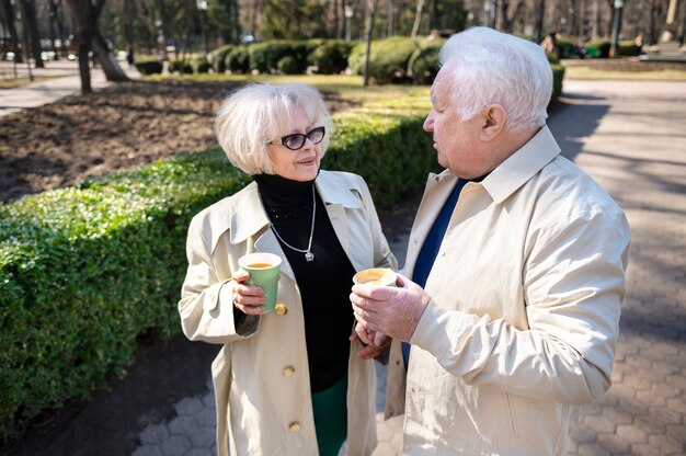 Medium shot smiley senior people with coffee cups