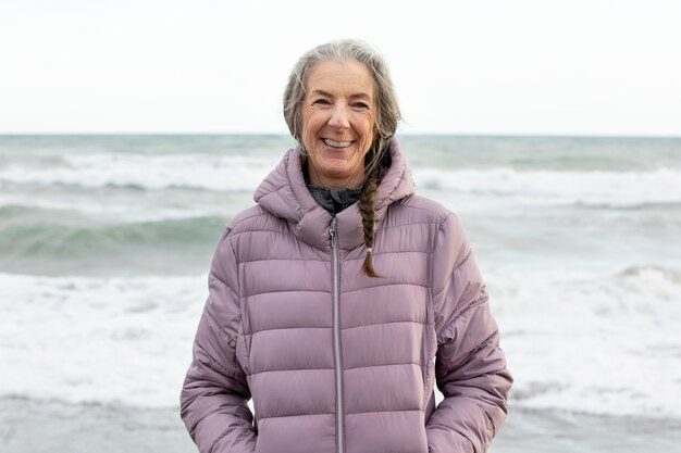 Medium shot smiley senior woman at beach