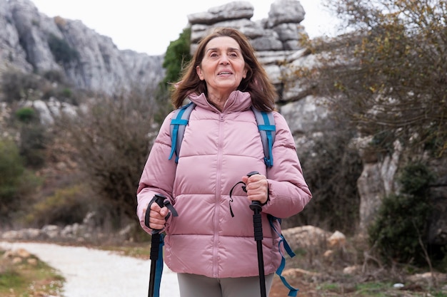 Free photo medium shot smiley senior woman hiking