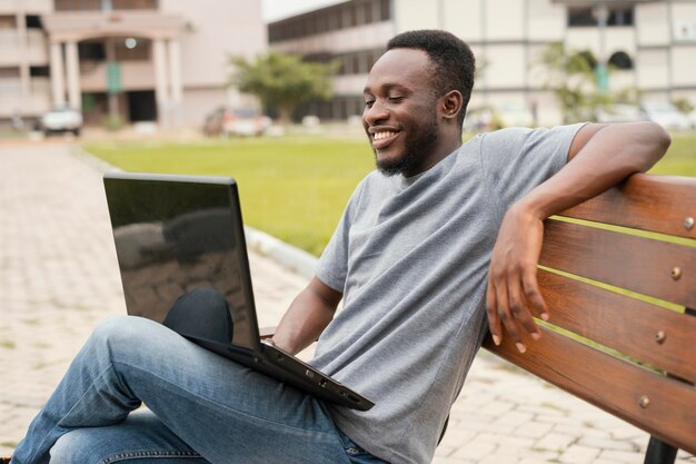 Foto gratuita allievo di smiley del colpo medio con il computer portatile