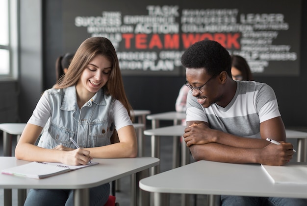 Medium shot smiley students in classroom