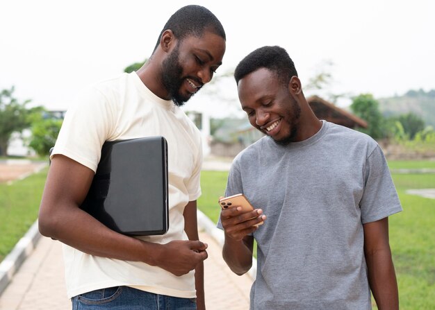 Medium shot smiley students with devices