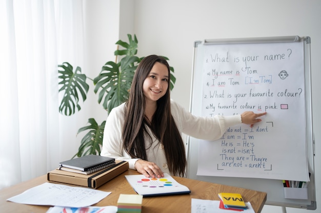 Free photo medium shot smiley teacher with whiteboard