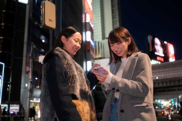 Medium shot smiley teens with smartphone