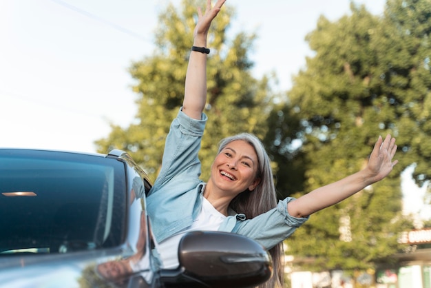 Free photo medium shot smiley woman in car