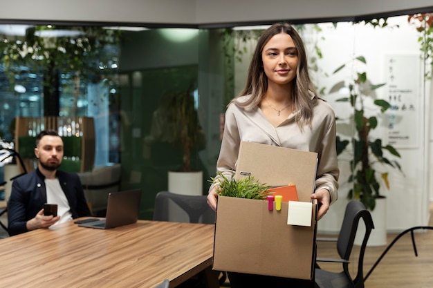 Free photo medium shot smiley woman carrying box