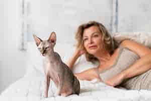 Foto gratuita donna sorridente con colpo medio e gatto a letto