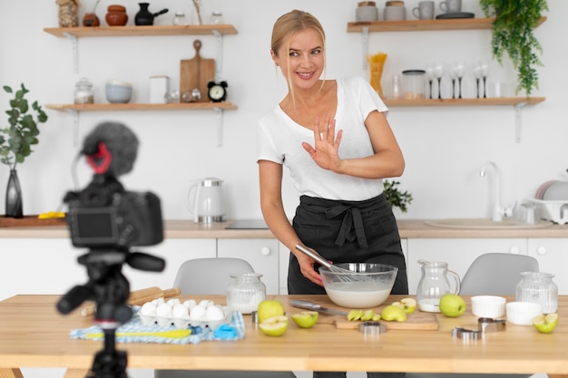 Donna sorridente di colpo medio che cucina