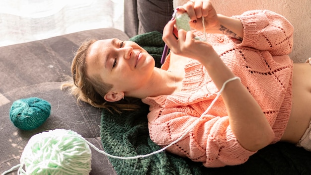 Medium shot smiley woman crocheting