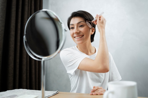 Free photo medium shot smiley woman doing skincare