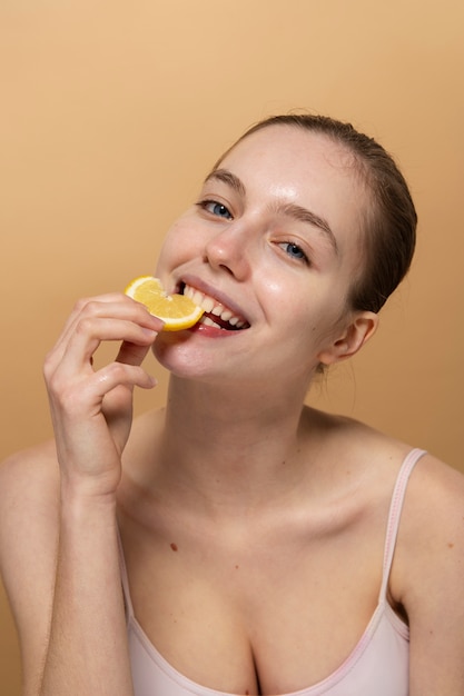 Medium shot smiley woman eating lemon