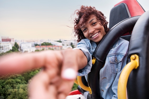 Free photo medium shot smiley woman on the ferris wheel