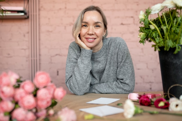 Free photo medium shot smiley woman at flower shop